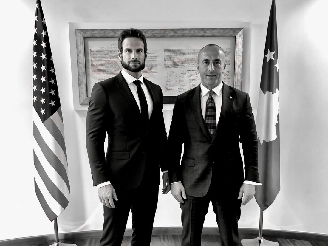 Bryan M. Ingram with the Prime Minister of Kosovo, beneath the United States and Kosovo flags
